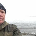 Author at beach gazing into fog